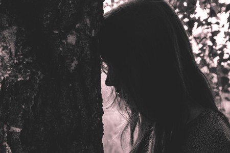 girl leaning tree
